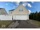 Home's rear exterior featuring a two-car garage and well-maintained lawn at 3432 Shepperton Blvd, Indianapolis, IN 46228