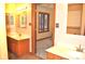 Bathroom featuring dual sinks with wooden cabinets and a view into the carpeted bedroom at 37 Trotters Run, Brownsburg, IN 46112