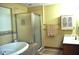 Bright bathroom featuring a soaking tub, walk-in shower with glass doors, and neutral tiling at 37 Trotters Run, Brownsburg, IN 46112
