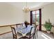 Dining room with a floral tablecloth, wood trim, chandelier, and a view to backyard at 37 Trotters Run, Brownsburg, IN 46112
