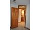 Hallway leading to an additional bathroom featuring wood-look flooring and a doorway at 37 Trotters Run, Brownsburg, IN 46112