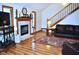 Welcoming living room with a fireplace, hardwood floors, and a cozy leather couch at 37 Trotters Run, Brownsburg, IN 46112