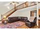 Spacious living room with hardwood floors, staircase, and a comfortable leather sofa at 37 Trotters Run, Brownsburg, IN 46112