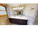 Bright bathroom featuring a double sink vanity with dark wood cabinets and modern fixtures at 3752 W North Wood Lake Dr, Columbus, IN 47201