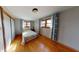 Cozy bedroom features hardwood floors, two windows, and light blue curtains at 3752 W North Wood Lake Dr, Columbus, IN 47201