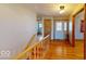 Well-lit hallway featuring hardwood floors and a staircase with wooden banister at 3752 W North Wood Lake Dr, Columbus, IN 47201