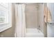Cozy bathroom with a tub and shower, featuring neutral tiles and a shower curtain at 5032 N Illinois St, Indianapolis, IN 46208