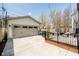 A large detached garage with a concrete driveway and adjacent fenced patio space at 5032 N Illinois St, Indianapolis, IN 46208