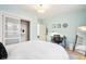 Calm bedroom with light blue walls, stylish mirrors, and a work space at 546 E Merrill St, Indianapolis, IN 46203
