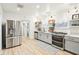Bright kitchen with stainless steel appliances, grey cabinets, and open shelving at 546 E Merrill St, Indianapolis, IN 46203