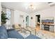 Bright living room with modern chandelier, wood floors, and a comfortable blue sectional sofa at 546 E Merrill St, Indianapolis, IN 46203