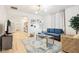 Bright living room with modern chandelier, wood floors, and a comfortable blue sectional sofa at 546 E Merrill St, Indianapolis, IN 46203