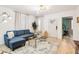 Bright living room with modern chandelier, wood floors, and a comfortable blue sectional sofa at 546 E Merrill St, Indianapolis, IN 46203