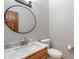 Clean half bath features a round mirror, marble countertop and wood vanity at 5517 Westbourne Ct, Greenwood, IN 46143