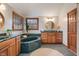 A full bathroom with a green marble tub, a wooden vanity, and a round mirror at 5517 Westbourne Ct, Greenwood, IN 46143
