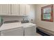 Well-equipped laundry room with modern washer and dryer, storage cabinets, and a bench at 5517 Westbourne Ct, Greenwood, IN 46143