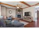 Comfortable living room featuring a stone fireplace, wood ceiling beams, and a plush sectional sofa at 5517 Westbourne Ct, Greenwood, IN 46143