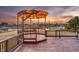 Inviting wooden deck with a pergola, lit with string lights, overlooking a serene pond at 5842 Oakmont Blvd, Bargersville, IN 46106