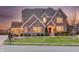 Elegant brick home features a well-kept lawn, attached garage, and warm, inviting lighting at 5842 Oakmont Blvd, Bargersville, IN 46106