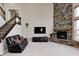 Living room featuring a stone fireplace, staircase, and comfortable leather seating at 5842 Oakmont Blvd, Bargersville, IN 46106