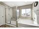 Main bathroom featuring a glass shower, soaking tub, and a bright window view at 5842 Oakmont Blvd, Bargersville, IN 46106