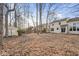 Home's large backyard with shed, covered in leaves and surrounded by mature trees, providing privacy at 6144 Maple Branch Pl, Indianapolis, IN 46221