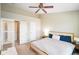 Bright bedroom with a ceiling fan, doors to the hall, closet, bedside tables, and a bed at 6144 Maple Branch Pl, Indianapolis, IN 46221