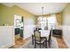 Well-lit dining room with classic design and large windows, adjoined by a modern, renovated kitchen at 6144 Maple Branch Pl, Indianapolis, IN 46221