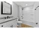 Bright bathroom features a granite countertop vanity and white tub/shower at 617 W 39Th St, Indianapolis, IN 46208