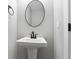 Pedestal sink in modern powder room with a round mirror at 617 W 39Th St, Indianapolis, IN 46208