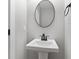 Modern bathroom with pedestal sink, large mirror, and stylish black fixtures at 617 W 39Th St, Indianapolis, IN 46208