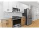 Kitchen featuring stainless steel appliances, light gray subway tile, and two-tone modern cabinets at 617 W 39Th St, Indianapolis, IN 46208