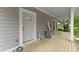 View of the covered porch with a wood deck and white door at 617 W 39Th St, Indianapolis, IN 46208