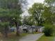 A charming home featuring mature trees with an attached basketball hoop in the driveway at 618 S Tibbs Ave, Indianapolis, IN 46241