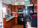 A kitchen featuring oak cabinets, black appliances, and a stainless steel sink at 618 S Tibbs Ave, Indianapolis, IN 46241