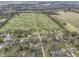 Expansive aerial view of a rural property featuring a large field, scattered homes, and surrounding trees and roadways at 6201 S Carroll Rd, Indianapolis, IN 46259