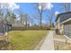 Open backyard featuring a large lawn, mature trees, shed, and trampoline, perfect for outdoor activities at 6201 S Carroll Rd, Indianapolis, IN 46259