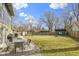 Expansive backyard featuring a patio with dining set, lush lawn, trampoline, and a charming blue storage shed at 6201 S Carroll Rd, Indianapolis, IN 46259