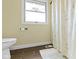 This bathroom has a toilet, a shower with a patterned curtain, and tile floors at 6201 S Carroll Rd, Indianapolis, IN 46259