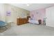 This carpeted bedroom has pink and tan walls, a ceiling fan, and a wooden bed with a patterned comforter at 6201 S Carroll Rd, Indianapolis, IN 46259