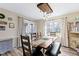 This dining room has a decorative light fixture, a large window, and a rustic wooden table at 6201 S Carroll Rd, Indianapolis, IN 46259