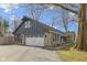 Charming home featuring a stone facade, grey siding, a white garage door, and well-maintained landscaping at 6201 S Carroll Rd, Indianapolis, IN 46259