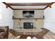 Close up on the stone fireplace with a wooden mantel and a flat-screen TV mounted above, in a cozy living room at 6201 S Carroll Rd, Indianapolis, IN 46259