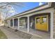 Welcoming front porch with arched supports, rocking chairs, and a cheerful yellow door at 6201 S Carroll Rd, Indianapolis, IN 46259