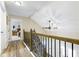 This hallway has hardwood floors, wood banisters, a ceiling fan, and access to the bedrooms at 6201 S Carroll Rd, Indianapolis, IN 46259