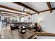 Open concept living room flowing into the kitchen, with wooden ceiling beams and a comfortable leather sectional at 6201 S Carroll Rd, Indianapolis, IN 46259