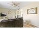 Comfortable living room with neutral tones, laminate flooring, a ceiling fan, and an open view into the dining room at 6201 S Carroll Rd, Indianapolis, IN 46259
