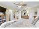 Bright main bedroom features plush bedding, a ceiling fan, and neutral decor creating a serene space at 6201 S Carroll Rd, Indianapolis, IN 46259