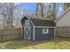 A backyard shed with white trim and a barn door design in a well-maintained, grassy yard at 6201 S Carroll Rd, Indianapolis, IN 46259