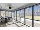 Relaxing sunroom featuring screened windows, an outdoor dining set, and views of the serene backyard at 6201 S Carroll Rd, Indianapolis, IN 46259